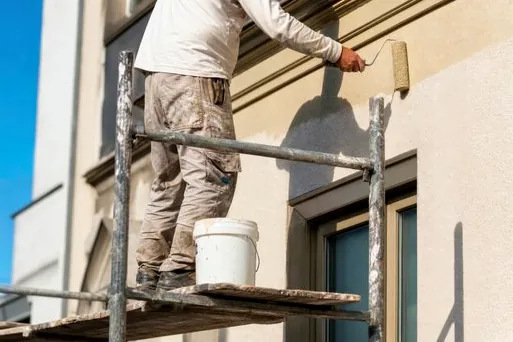 Crew on scaffolding converting a beige stucco home to white in Manhattan Beach